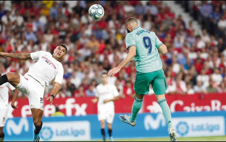 Karim Benzema cabecea hacia la portería del Sevilla para hacer el gol que puso al Real Madrid en la parte alta de LaLiga. AP