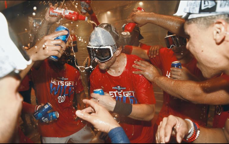 Jugadores de Washington celebran con un baño de cerveza tras los dos juegos de ayer ante Filadelfia. AP