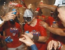 Jugadores de Washington celebran con un baño de cerveza tras los dos juegos de ayer ante Filadelfia. AP