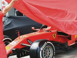 Un mecánico de Ferrari cubre de la lluvia el auto de Charles Leclerc, en el Circuito Internacional de Sochi. AP