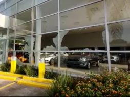 La balacera a las fachadas del inmueble destrozó los cristales y ocasionó daños a varios vehículos que estaban en exhibición. YOUTUBE