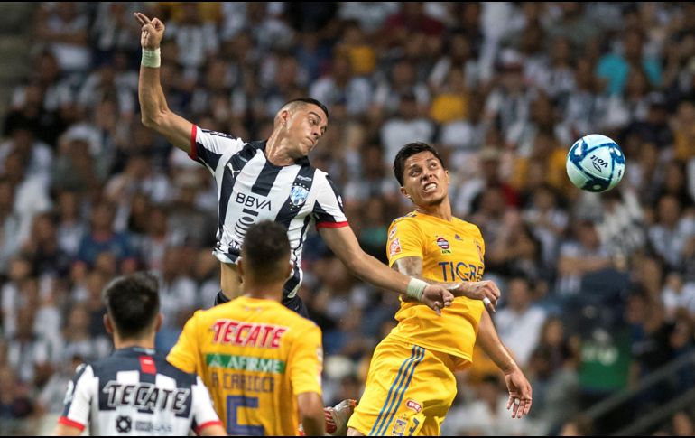 Rogelio Funes Mori (i) de Rayados de Monterrey disputa el balón con Carlos salcedo (d) de Tigres este sábado. EFE/M. Sierra