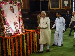 El primer ministro Narendra Modi deposita unas ofrendas frente a un enorme retrato de Gandhi. AFP/M. Sharma
