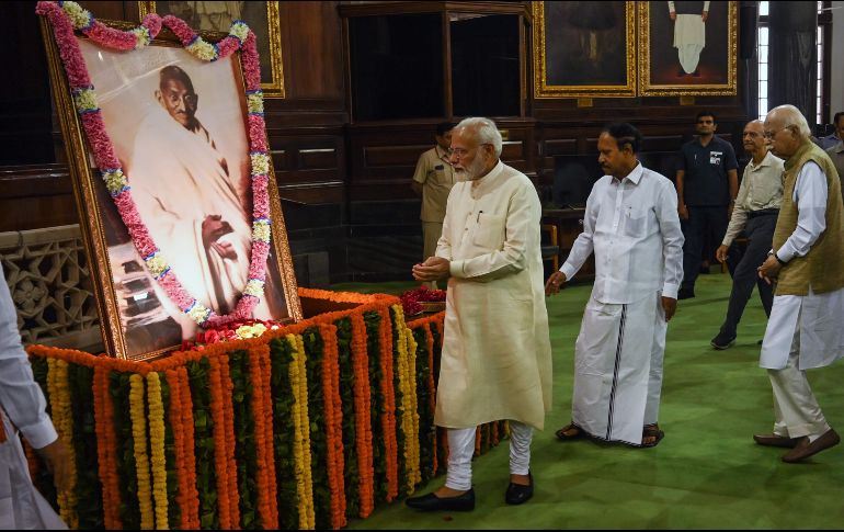 El primer ministro Narendra Modi deposita unas ofrendas frente a un enorme retrato de Gandhi. AFP/M. Sharma