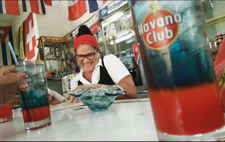Felicidad. Una tabernera de la Habana Vieja sonríe al convivir con los turistas, a quienes muestra un mapa con los sitios de interés. EL INFORMADOR/I. de Loza
