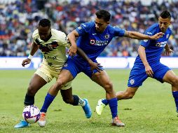 El lateral Adrián Aldrete (c), de Cruz Azul, disputa el balón este sábado con el extremo Alex Ibarra (i), del América, durante el partido. EFE/J. Méndez