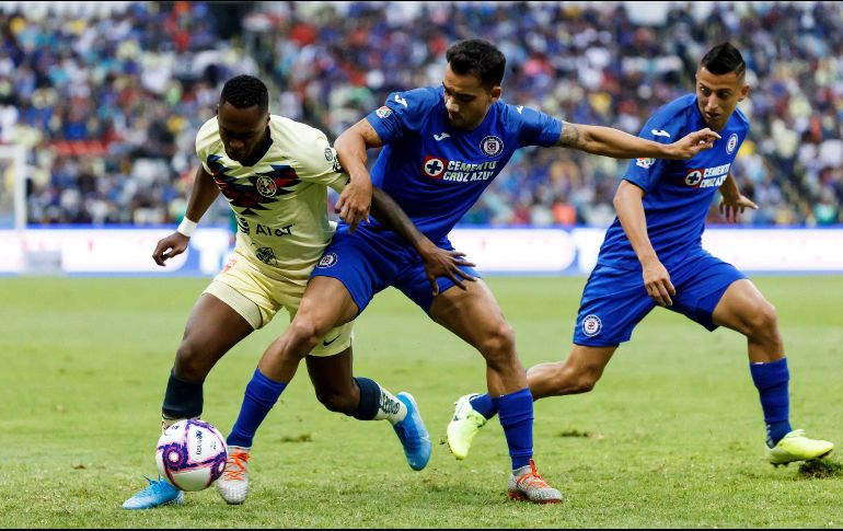 El lateral Adrián Aldrete (c), de Cruz Azul, disputa el balón este sábado con el extremo Alex Ibarra (i), del América, durante el partido. EFE/J. Méndez