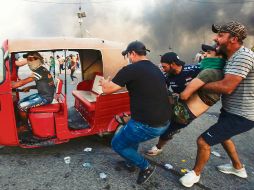 Manifestantes trasladan a un herido tras la refriega con las fuerzas del orden en la capital iraquí. AFP