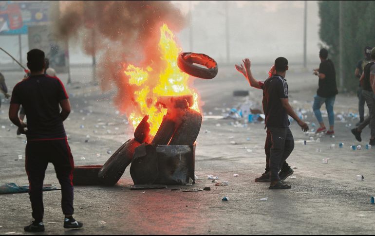 Hombres alimentan el fuego por las marchas contra la falta de oportunidades en el país árabe. AP