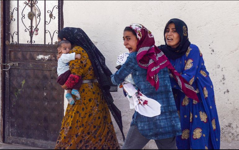 Un grupo de mujeres corre para refugiarse ante los bombardeos que azotan el noroeste de Siria. AP/I. Coskun