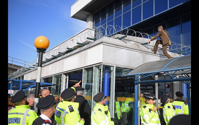 Un  manifestante se sube a un techo en las instalaciones de la terminal. AFP/D. Leal-Olivas