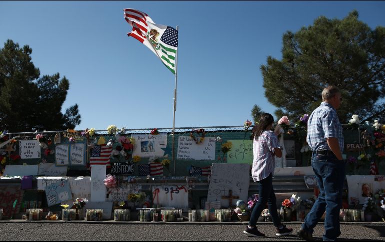 Varias personas caminan hoy frente al memorial instalado a las afueras de la tienda Walmart de El Paso, Texas. En el ataque del 3 de agosto murieron 22 personas.EFE/L. Torres