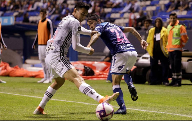 Omar Fernández (d) de Puebla disputa el balón con Ismael Govea (i) de Atlas este viernes durante el partido. EFE/H. Ríos