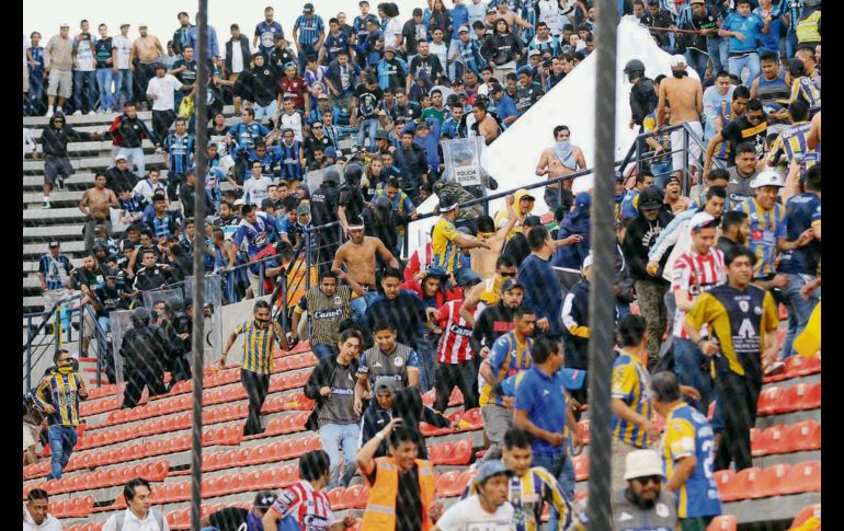 Aficionados del Atlético de San Luis corren en las gradas tras las agresiones de las barras del Querétaro. IMAGO7