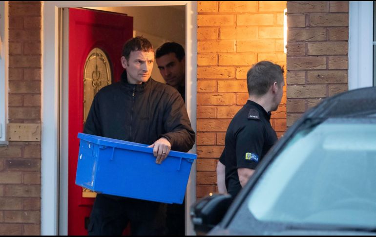 Policías salen de la casa de Joanna y Thomas Maher, dos de los detenidos, con una caja de evidencia. AP/J. Roberts