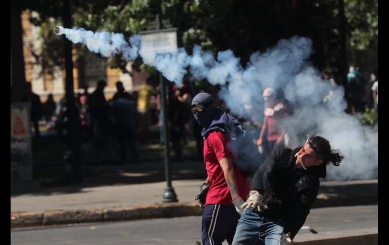 Un manifestante devuelve una bomba de gas lacrimógeno frente al Palacio de La Moneda. EFE/F. Bizerra Jr.