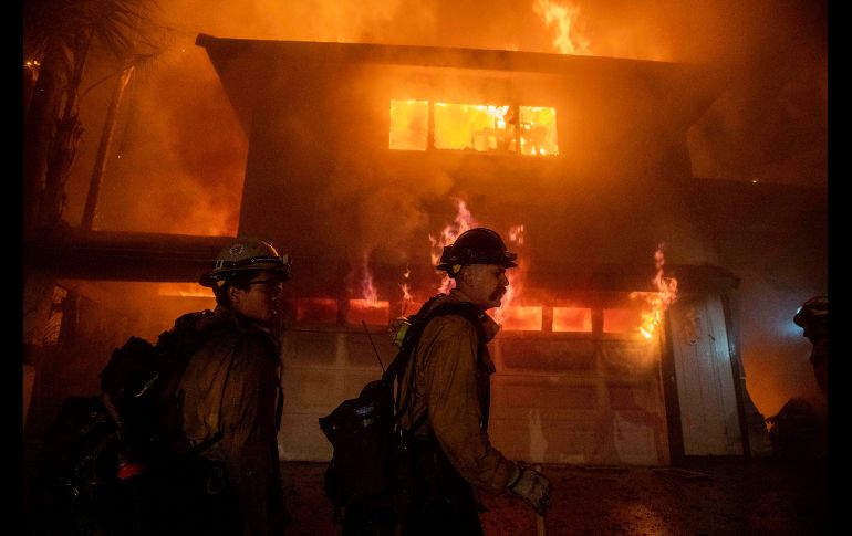 Bomberos laboran para evitar que el fuego se propague en un vecindario de San Bernardino. AP/C. Monterrosa