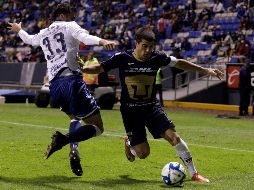 Néstor Vidrio (i), de Puebla, y Víctor Malcorra, (d) de Pumas, pelean por el balón durante el encuentro de este viernes. EFE/H. Ríos