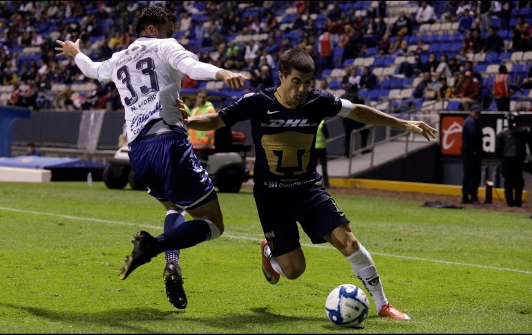 Néstor Vidrio (i), de Puebla, y Víctor Malcorra, (d) de Pumas, pelean por el balón durante el encuentro de este viernes. EFE/H. Ríos