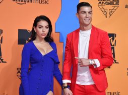 Ronaldo vistió un traje color rojo y tenis blancos, mientras que Georgina Rodríguez lució un vestido abierto de la pierna. EFE / R. Caro