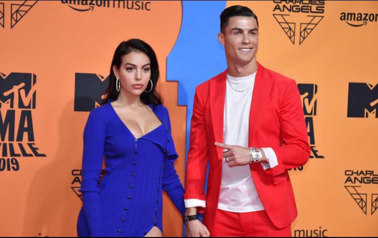 Ronaldo vistió un traje color rojo y tenis blancos, mientras que Georgina Rodríguez lució un vestido abierto de la pierna. EFE / R. Caro