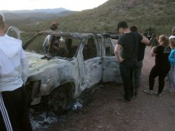 Miembros de la familia LeBarón observan un vehículo calcinado donde fueron ultimados sus familiares cuando circulaban por las comunidades de Bavispe y Ejido Pancho Villa. EFE/M. Hartz