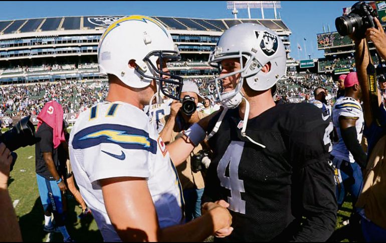 Philip Rivers (izq.) ha tenido buenas actuaciones visitando el Coliseo de Oakland; sin embargo, Derek Carr (der.) busca ponerle un alto y hacer que los Raiders se despeguen más en el Oeste de la Americana. AFP