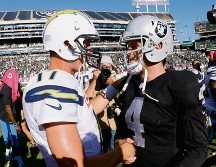 Philip Rivers (izq.) ha tenido buenas actuaciones visitando el Coliseo de Oakland; sin embargo, Derek Carr (der.) busca ponerle un alto y hacer que los Raiders se despeguen más en el Oeste de la Americana. AFP