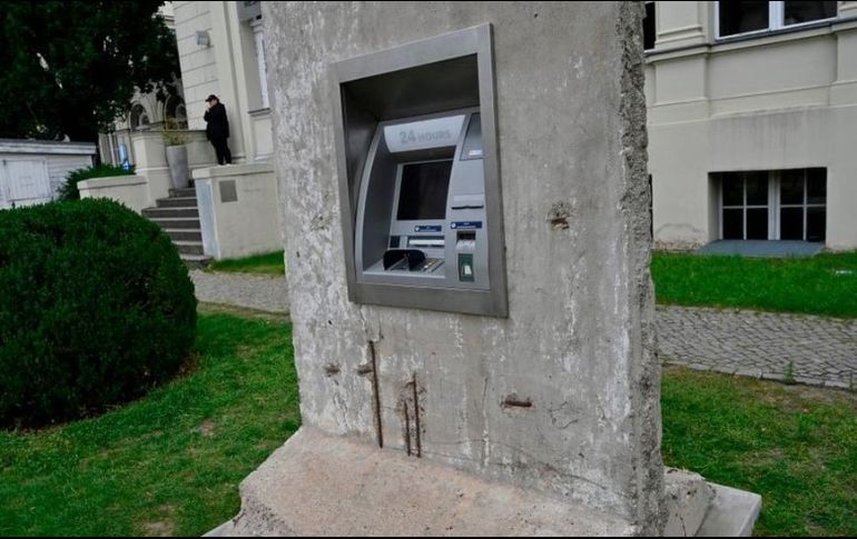 Una intervención artística en Berlín muestra un pedazo del Muro que sostiene un cajero electrónico. GETTY IMAGES