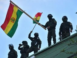 Uniformados bolivianos ondean banderas del país en el techo de una unidad policial este viernes en Cochabamba. EFE/J. Abrego