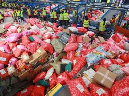 Trabajadores revisan paquetes en un centro de procesamiento de correo durante el Día de los Solteros en Yangzhou, China. EFE/M. Delong