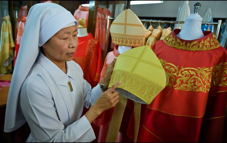 En una pequeña sala del convento, una decena de costureras trabajan incansablemente para unir telas de colores en seda artesanal, bajo la atenta mirada de la hermana Sukanya. AFP/R. Gacad