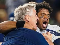 Russell Wilson (der.), quien completó 24 de 34 pases para 232 yardas y una anotación, celebra el triunfo de anoche con su entrenador Pete Carroll. AP / T. Avelar
