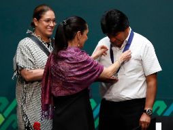 Claudia Sheinbaum coloca la medalla del reconocimiento a Evo Morales. AP/E. Verdugo