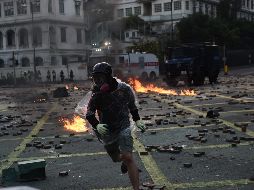 Un  manifestante corre tras arrojar una bomba molotov a policías afuera de la Universad Politécnica en Hong Kong. AFP/Y. Aung Thu