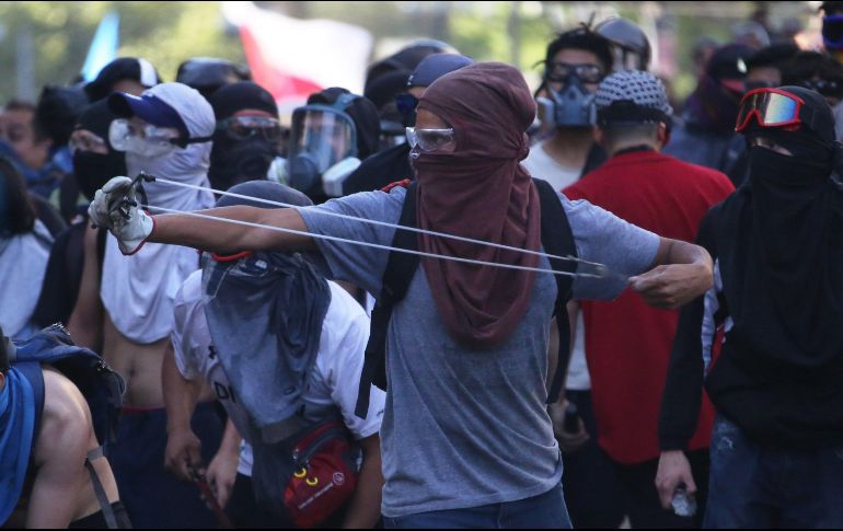 Manifestantes con gafas de protección se enfrenta a la policía antidisturbios. EFE/E. González