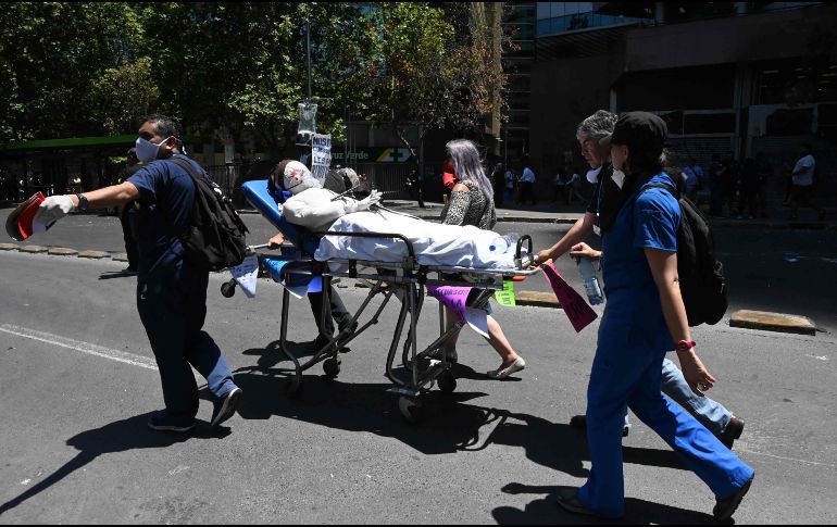 Manifestantes marchan con un maniquí simulando a un herido. AFP/J. Ordóñez