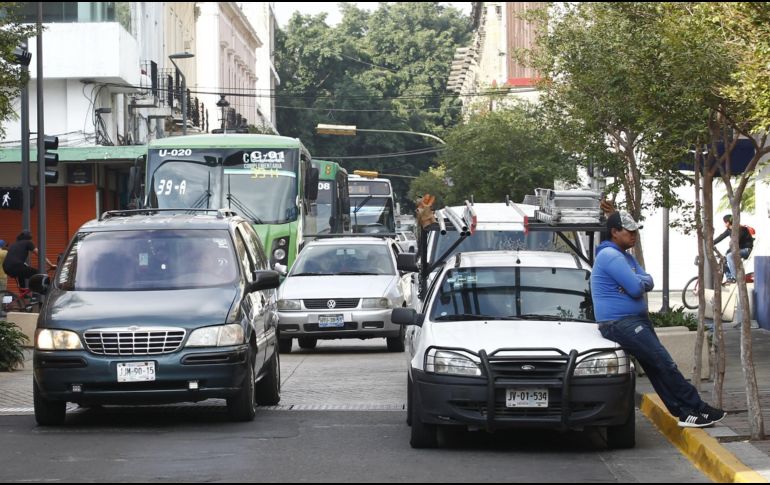 Un trabajador aguarda apoyado en su vehículo mientras el tráfico de la calle Juan Manuel se acumula. EL INFORMADOR/A. Camacho