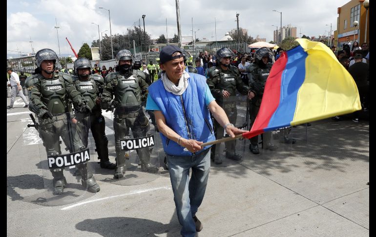 Un hombre protesta frente a policías en Bogotá. EFE/M. Dueñas