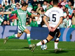 Andrés Guardado dispara ante un defensor del Valencia, en el triunfo bético. AFP