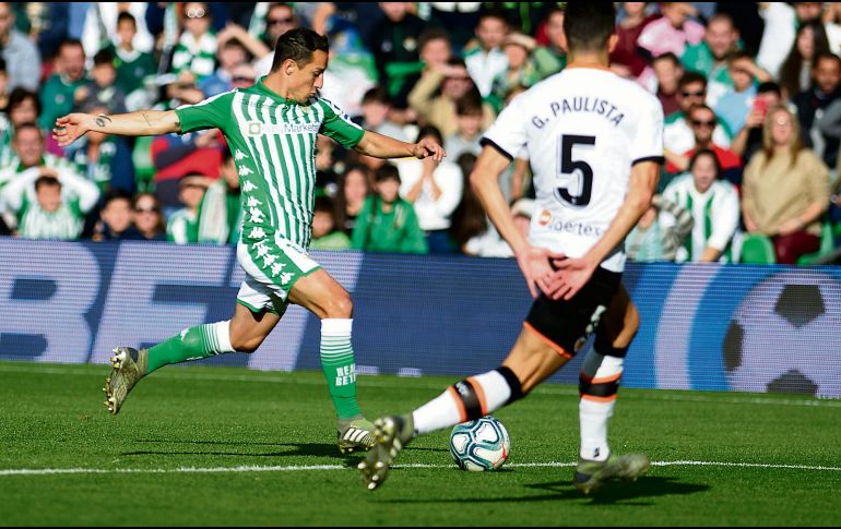 Andrés Guardado dispara ante un defensor del Valencia, en el triunfo bético. AFP