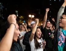 Simpatizantes de candidatos pro democracia celebran en Hong Kong tras la derrota del legislador en funciones Junius Ho. AFP/P. Fong