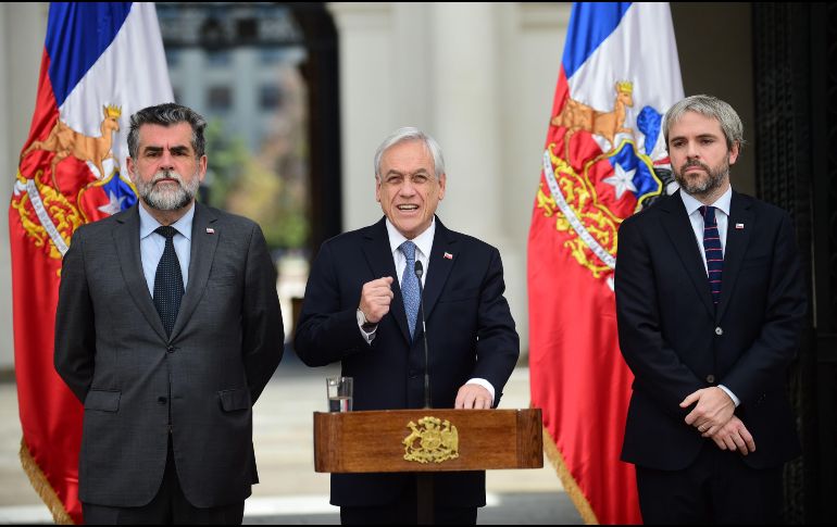 Piñera (c) urgió al Congreso para que despache proyectos de ley que establecen penas para los encapuchados, saqueadores y quienes levanten barricadas. AFP/J. Ordóñez