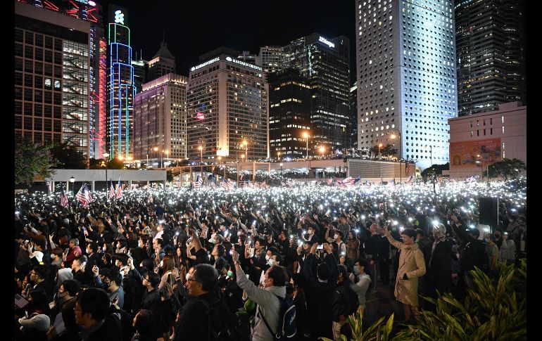 Manifestantes alzan sus teléfonos durante una concentración en Hong Kong para agradecer la legislación promulgada por el presidente Donald Trump. AFP/A. Wallace