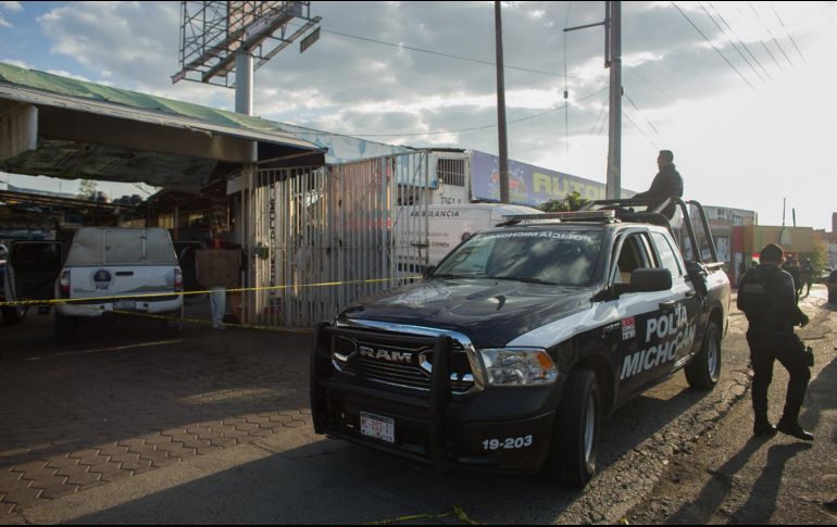 Policías estatales vigilan en el exterior de un local de lavado de automóviles, donde un grupo armado asesinó a dos personas. EFE/I. Villanueva
