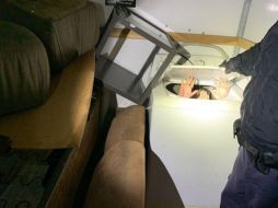 Fotografía cedida por autoridades migratorias que muestra a uno de los chinos, oculto en una lavadora, al momento de su detención. EFE/CBP