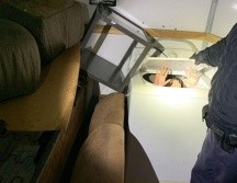 Fotografía cedida por autoridades migratorias que muestra a uno de los chinos, oculto en una lavadora, al momento de su detención. EFE/CBP