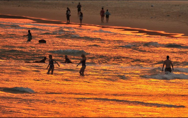 Personas se refrescan en la playa Bondi en Sídney. AFP/F. Khan