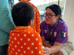 Empleada del INM recibe a migrantes en el aeropuerto de Guadalajara. En el primer vuelo llegaron 150 repatriados. EFE/INM