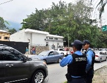 Dos miembros de la policía nacional resguardan las instalaciones de la morgue judicial del Ministerio Público hondureño. EFE/J. Valle